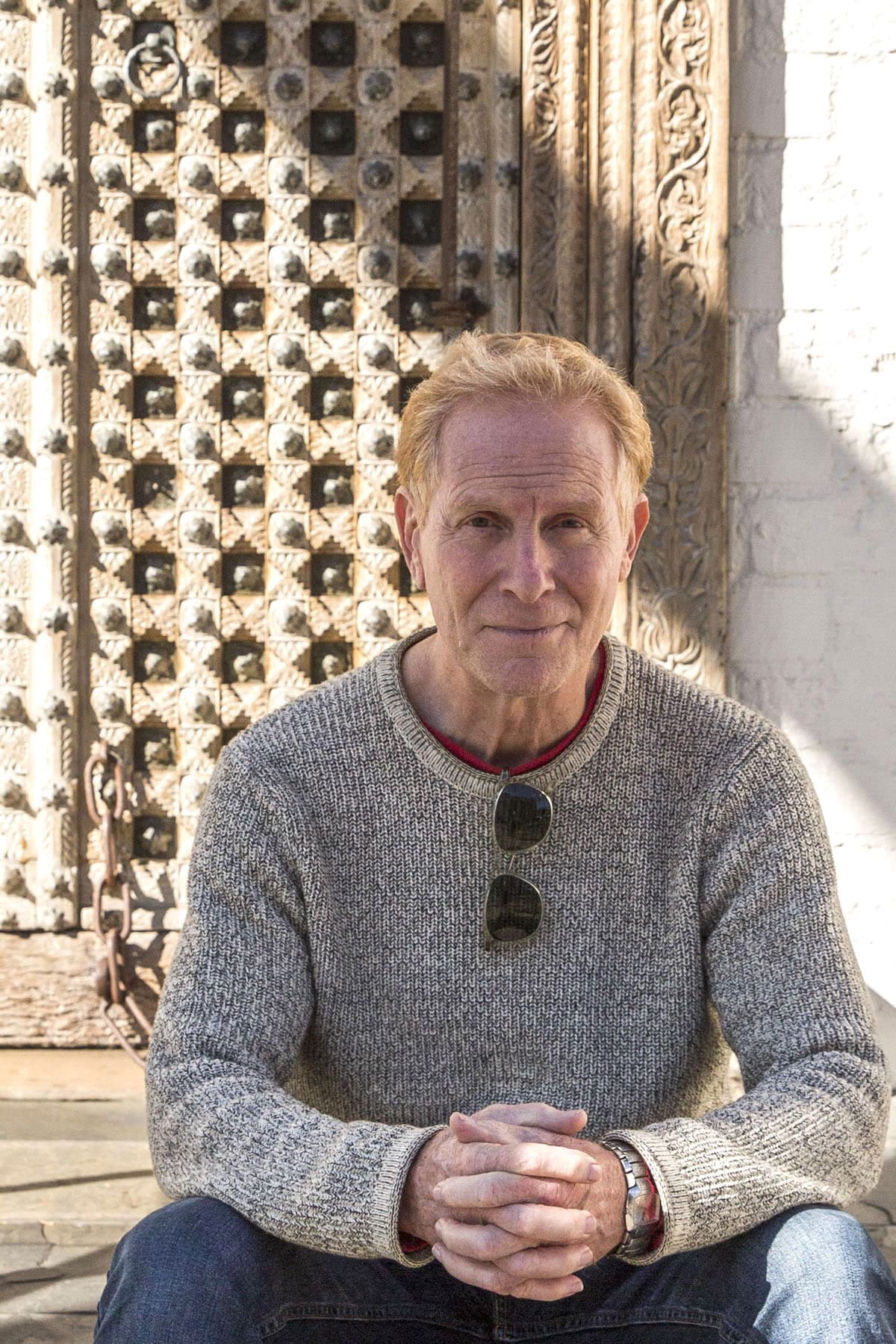 Artist Jorg Dubin seated in front of The Honarkar Foundation Gallery in Laguna Beach.