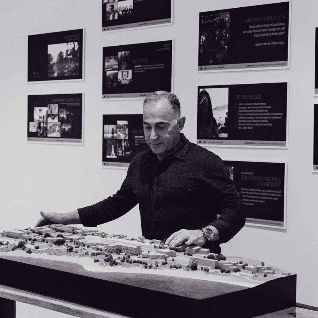 Mo Honarkar studies an architectural model surrounded by development and design concepts.